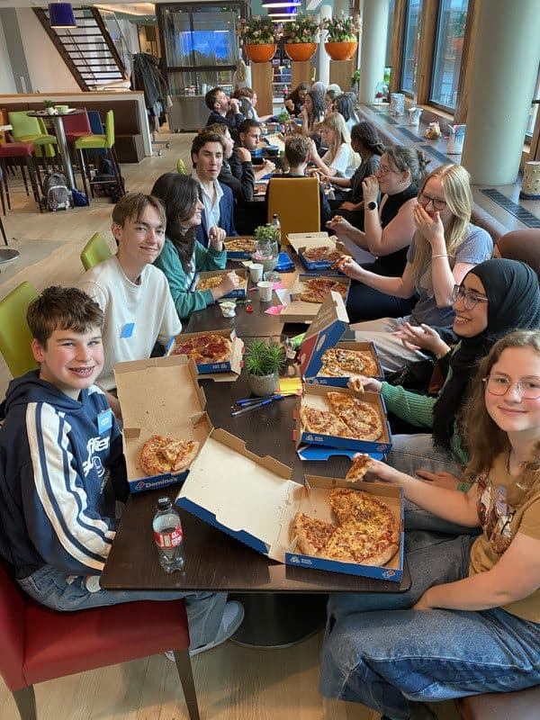 Leerlingen aan tafel tijdens een pizzapanel